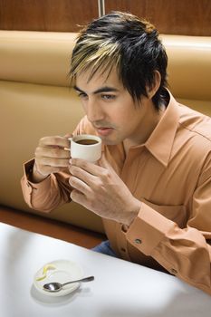 Hispanic mid adult man drinking expresso.