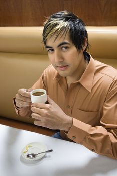 Hispanic mid adult man drinking expresso.