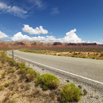 Utah landscape with distant mountains and two lane road.