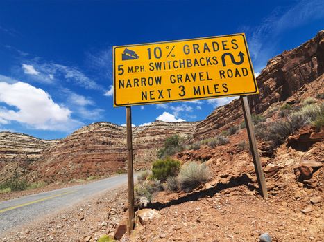 Road sign warning steep grade in Utah mountainous area.