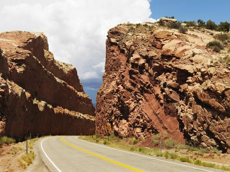 Rural road dug through large rock formation in Utah.