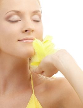 portrait of girl with yellow feathers over white background