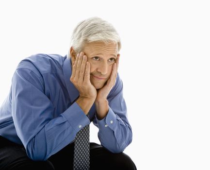 Middle aged Caucasian man with head resting in hands looking bored.