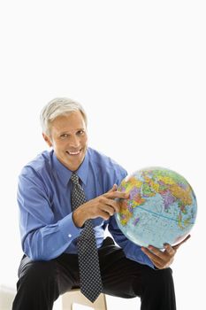 Middle aged Caucasian man pointing on globe.