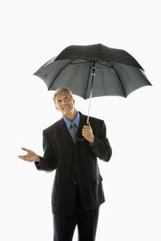 Caucasian middle aged businessman holding umbrella and gesturing.