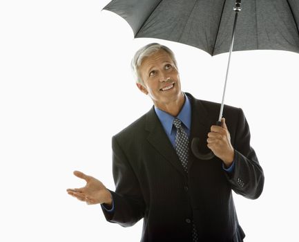 Caucasian middle aged businessman holding umbrella and gesturing.