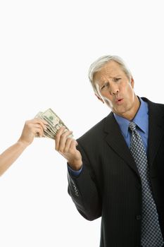 Woman holding money with Caucasian middle aged businessman making facial expression.