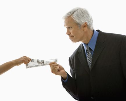 Caucasian middle aged businessman pulling one hundred dollar bill from woman.