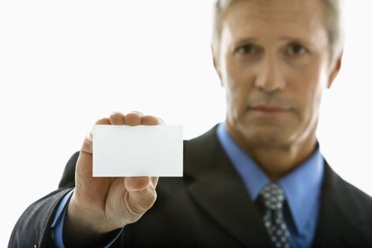 Caucasian middle aged man holding business card and looking at viewer.