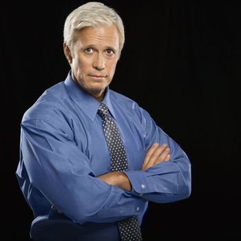 Caucasian middle aged businessman looking at viewer with arms crossed.