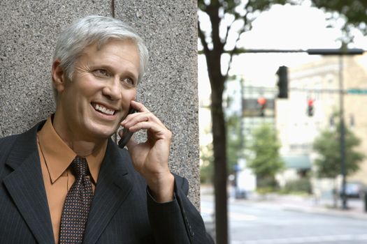 Caucasian middle aged businessman talking on mobile phone.