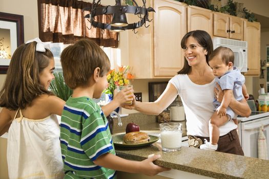 Hispanic family in kitchen with breakfast.