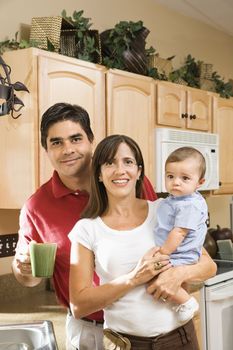 Hispanic family portrait in home kitchen with baby.