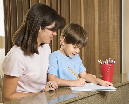 Hispanic mother helping son with homework.