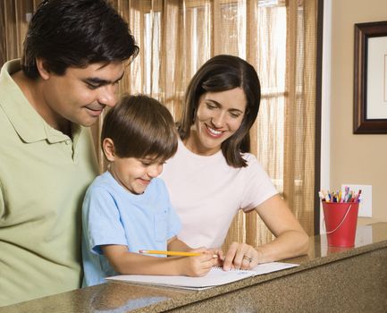 Hispanic parents helping son with homework.