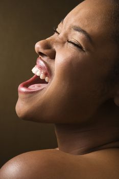 Portrait of smiling African-American young adult female singing.