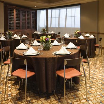 Restaurant interior with table setting and chairs.