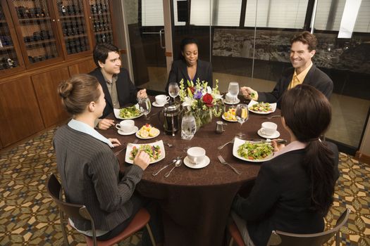 High angle of diverse group of businesspeople in restaurant eating.