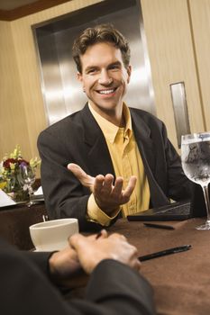 Caucasian businessman gesturing during meeting.