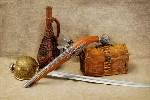 Still life with bottle, rapier, sword, pistol and chest