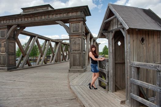 View of young, sexy woman, old-time bridge and watch box.
