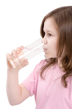 The girl drinks water from a transparent glass