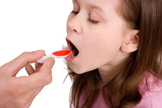 Hand stretching a spoon with a medicine to the sick child