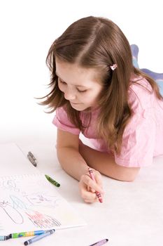 The girl draws colour pencils in an album