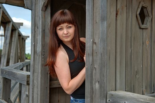 Young, beautiful woman looks at the camera from old-time watch box.
