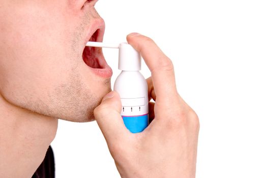 On a white background the man sprays a medicine to itself in a mouth