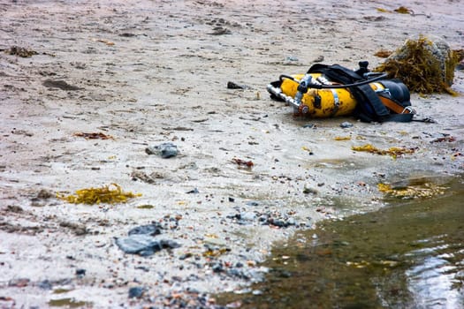 Yellow cylinders lying on sandy coast for diving