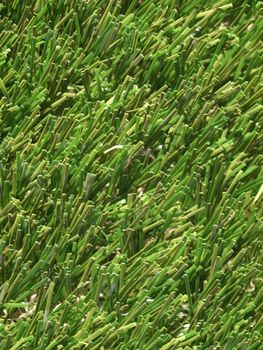 Detail of green grass artificial lawn meadow, useful as a background