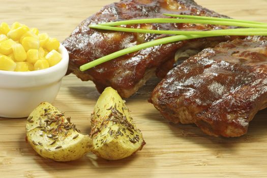 Grilled spare ribs with potatoes and corn