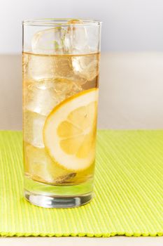 Ice tea with lemon on the lime green table