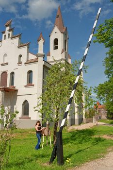 View of church, young woman and barrier across the road.
