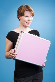 Woman holding a pink suitcase over a blue background