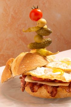 Supersized bacon, cheese and egg sandwich with picles