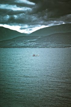 two men in a boat in the middle of the lake