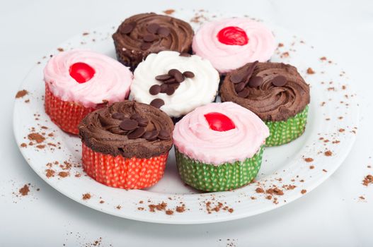 Colorful, delicious cupcakes on a white plate decorated with cinnamon sprinkles