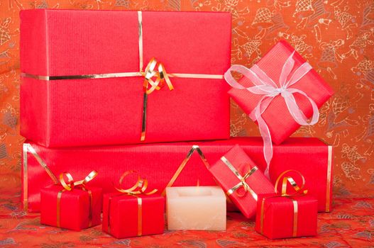 Red and gold gift boxes with a candle on a Xmas background