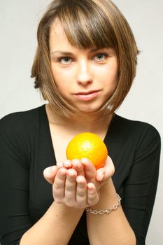 young girl with orange fruit in isolated white background