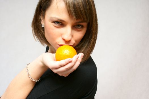 young girl with orange fruit in isolated white background