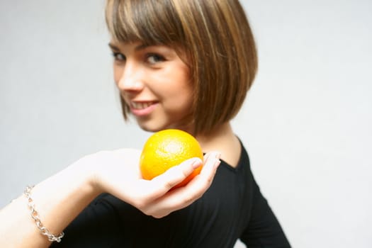 young girl with orange fruit in isolated white background