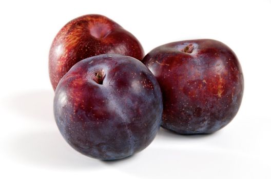 Three red plums on a white background.