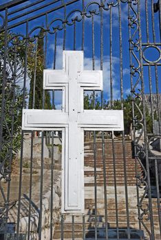 Cross at Christian Orthodox cemetery entrance on a sunny day.