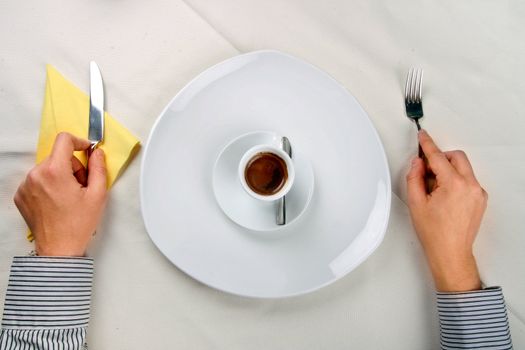 Man waiting near a plate with a cup of coffee on it