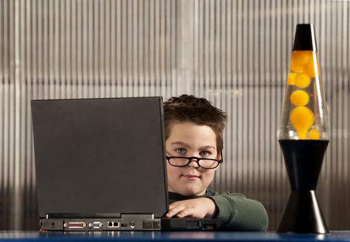 Cute young boy dressed as an adult working on a laptop computer