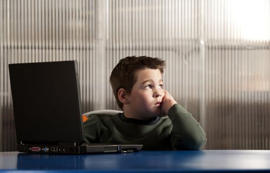 Cute young boy working on a laptop computer