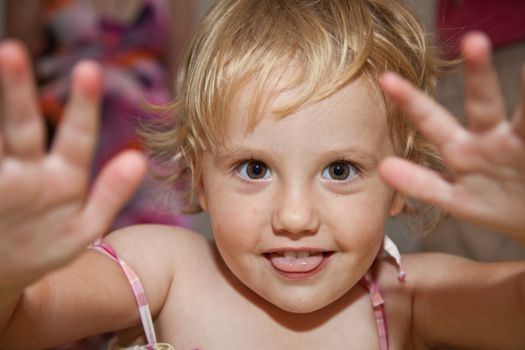 Portrait of cute little European toddler girl having fun and smiling.
