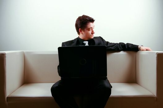 Businessman on lounge holding a laptop